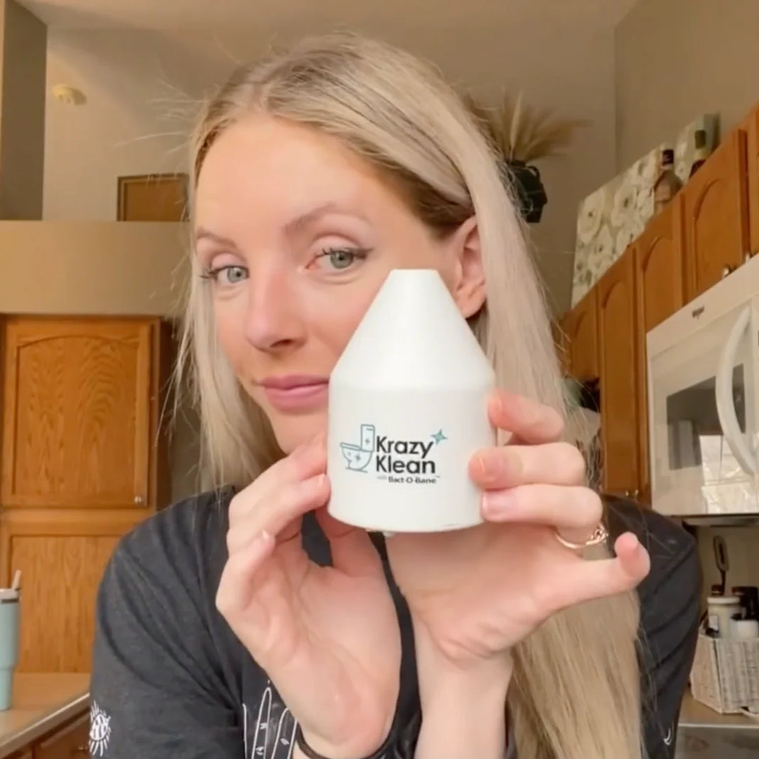 Woman holding Krazy Klean device in a kitchen.